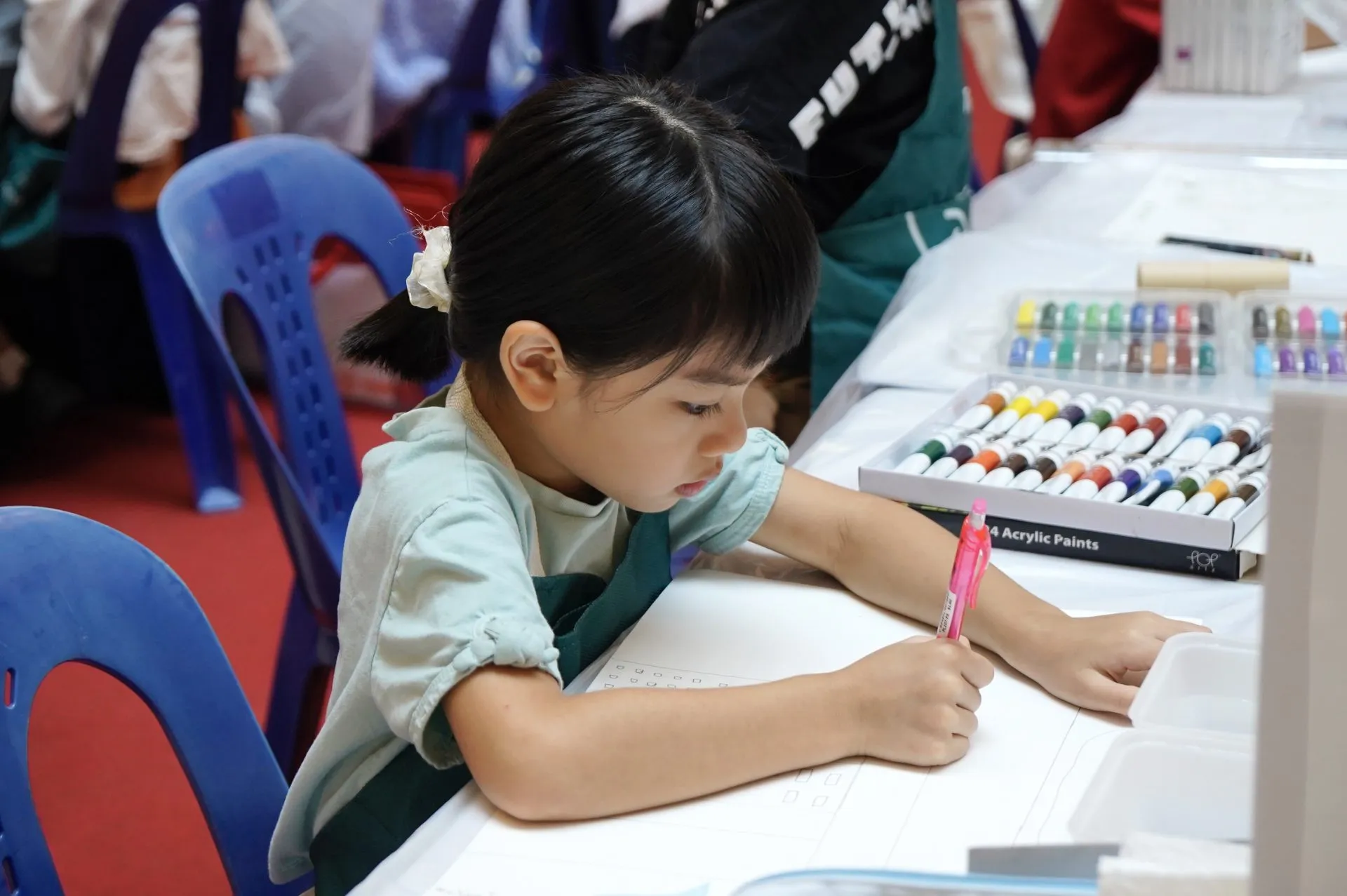 A young child's paint-covered hands during an art class